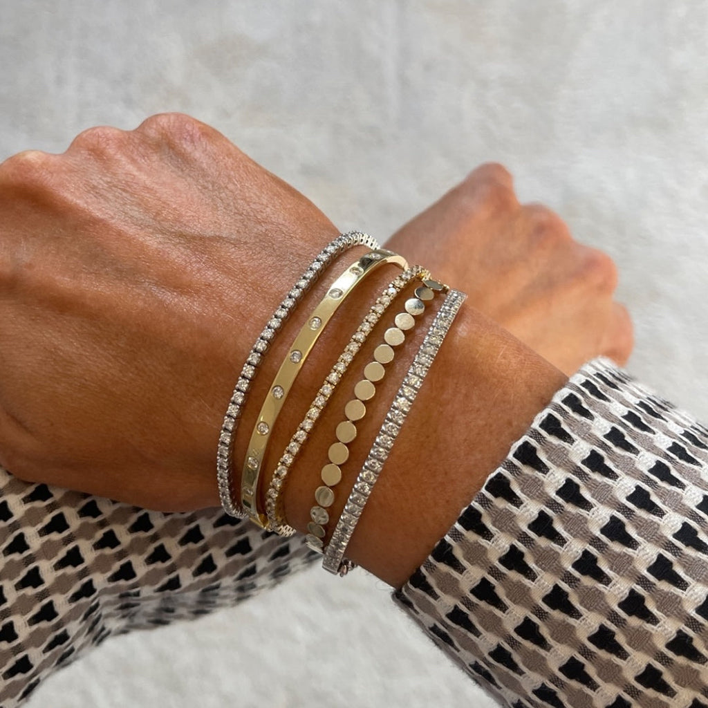 Gold bangle with diamonds in yellow gold styled with other bangles