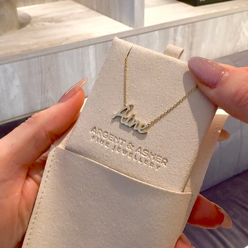 Classic gold name necklace lifted from its Argent & Asher pouch