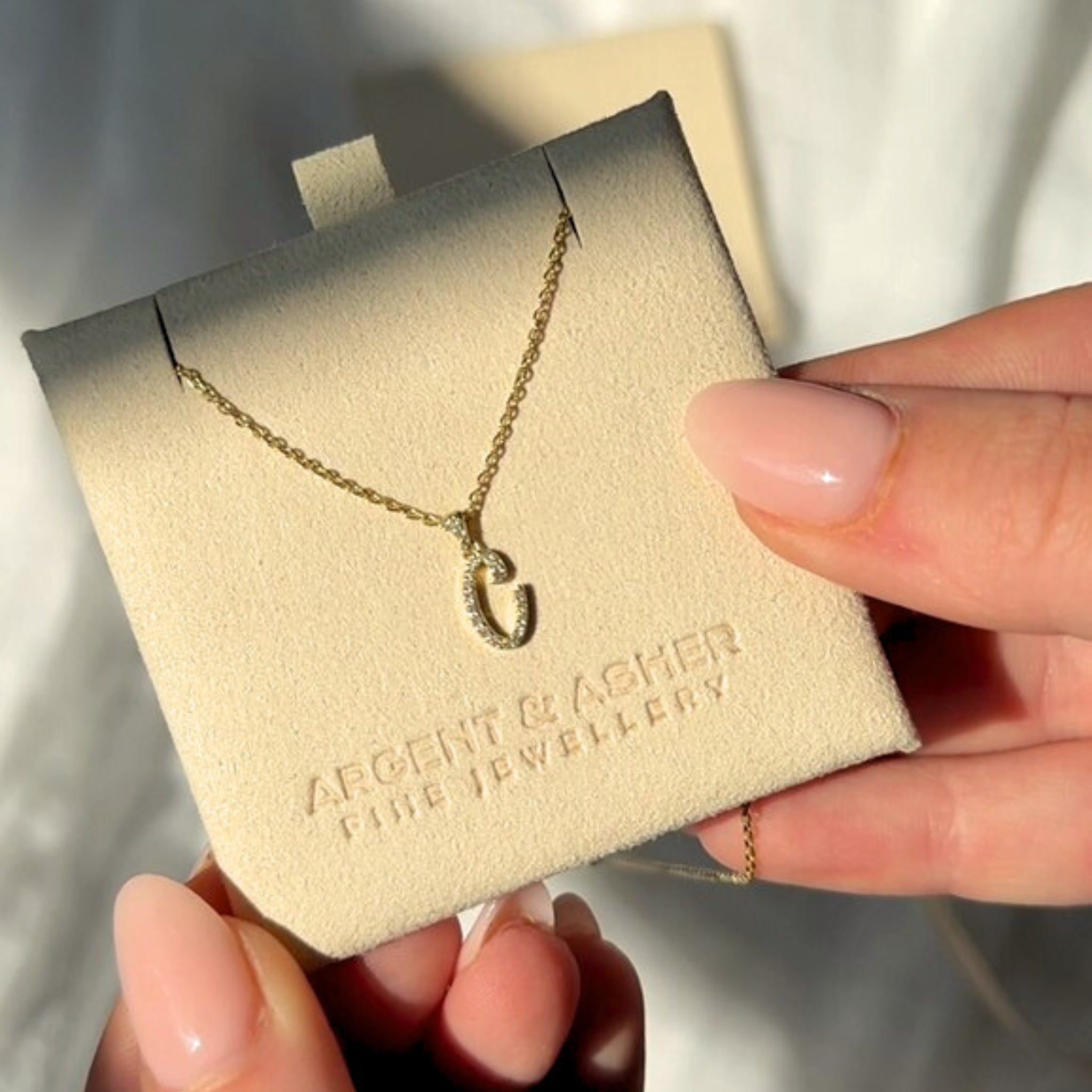 letter necklace styled in argent and asher packaging