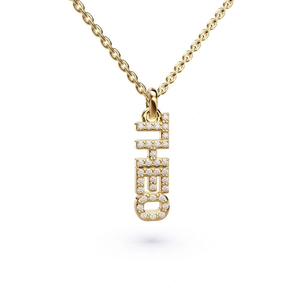 Dainty diamond name necklace worn layered with gold chains, custom Name in Diamonds pendant handmade by Argent + Asher in London